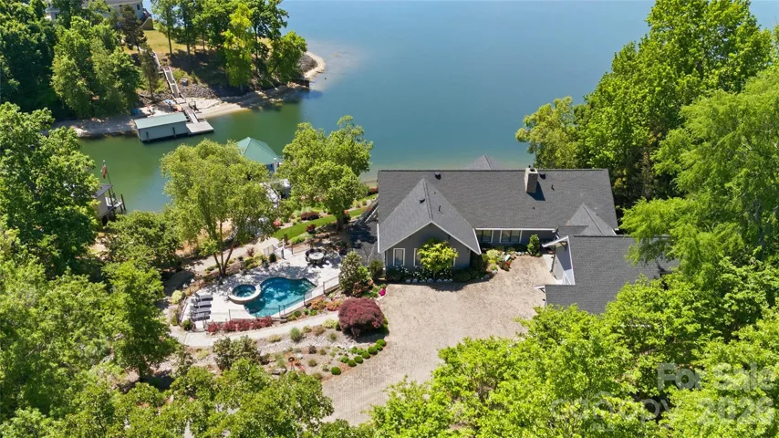 Outdoor living is unmatched, with a massive Trex deck, covered patio, beautifully landscaped yard, and a resort-style saltwater pool and hot tub