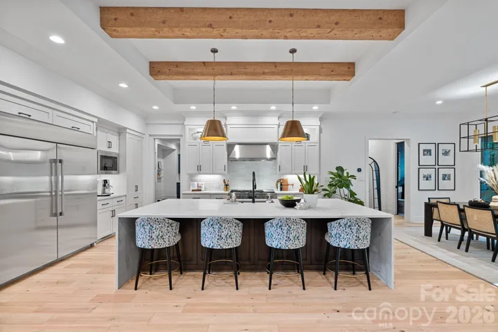 Massive kitchen island with statement piece waterfall quartz countertop