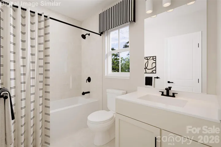  The shared bathroom features sleek, modern lines and a bright, inviting design, complete with a stylish tub for added comfort and convenience.