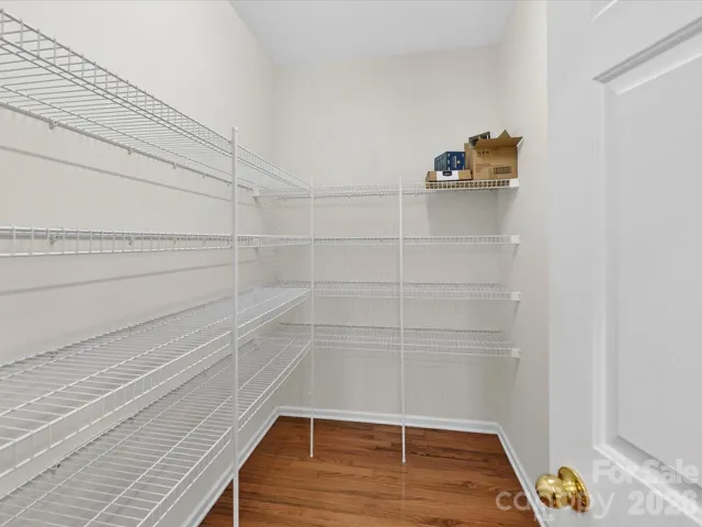 Large walk-in pantry with extensive shelving provides exceptional storage and organization for all your kitchen essentials.