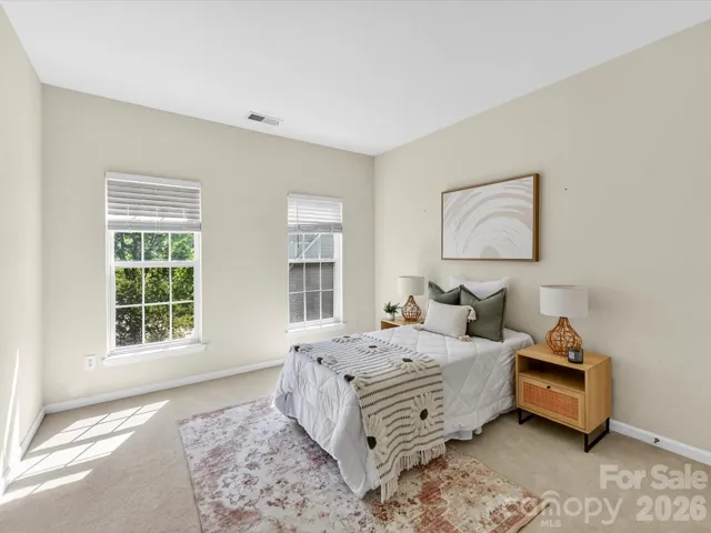 Bright secondary bedroom with soft natural light, neutral tones, and ample space for comfortable living.