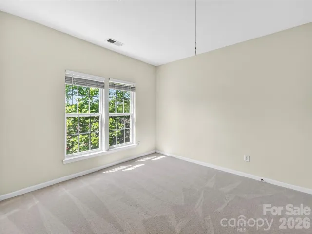 Spacious third bedroom with large windows, ample closet space, and soft natural light creates a comfortable and inviting retreat.