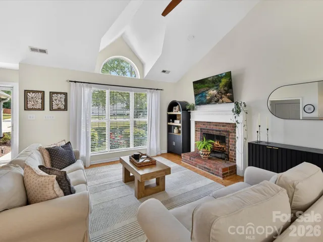 Open-concept great room offers seamless flow to the kitchen and dining areas, highlighted by vaulted ceilings, warm floors, and comfortable gathering space.