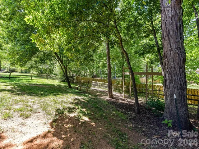 Private, tree-lined backyard offers a peaceful setting with mature landscaping, natural shade, and plenty of space to enjoy the outdoors.