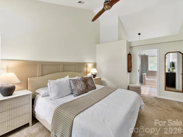 Generously sized primary suite features vaulted ceilings, plush carpeting, abundant natural light, and a private en-suite bath for added comfort.