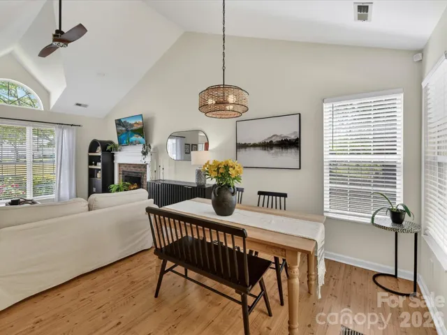 Bright dining area features vaulted ceilings and an open view to the great room with cozy fireplace.