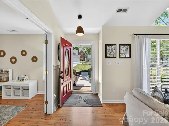 Bright and welcoming foyer with warm floors, abundant natural light, and an open flow into the main living areas.