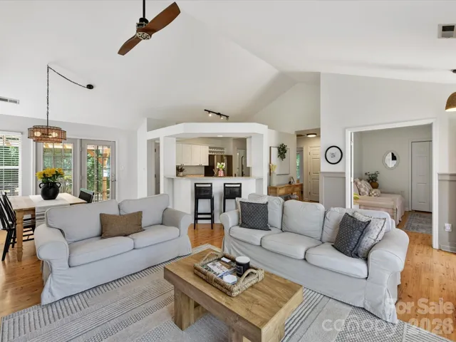 Open-concept great room offers seamless flow to the kitchen and dining areas, highlighted by vaulted ceilings, warm floors, and comfortable gathering space.