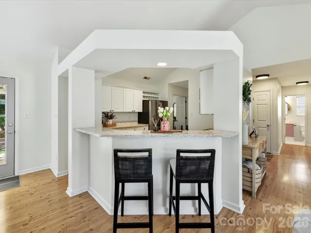 Inviting kitchen bar seating features granite countertops, a breakfast bar, and seamless flow to the open living spaces.