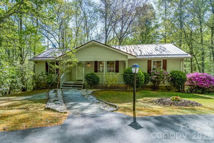 Front Exterior (Alternate View) – Inviting curb appeal with a gently curved walkway leading to the porch, complemented by manicured shrubs and seasonal color.