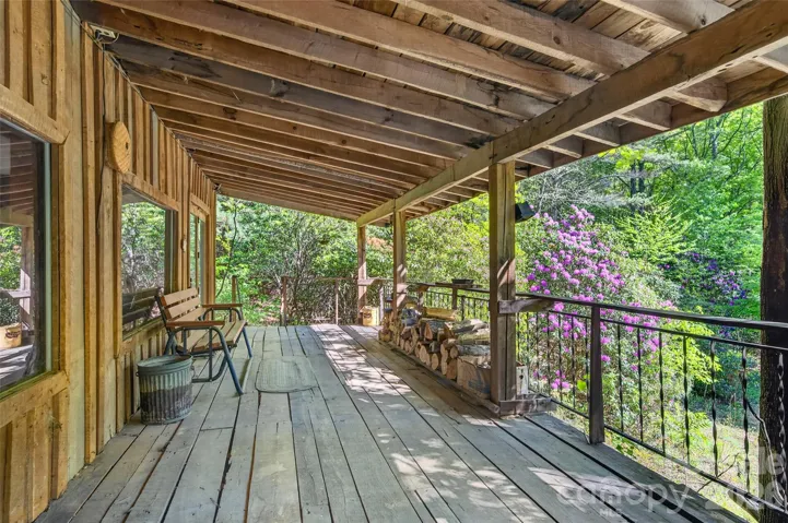 Covered front porch extending the full length of the cabin with views of the circular drive and spring-fed pond.