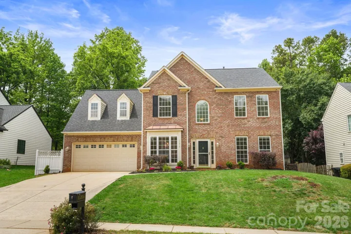 Welcoming front elevation with timeless brick, fresh paint, and mature neighborhood charm.