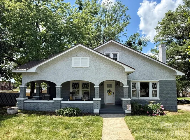 Front of home featuring arches on the wraparound porch