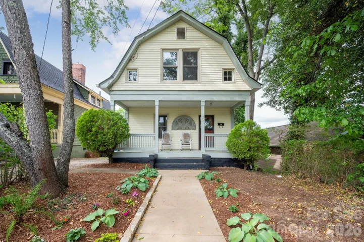 Covered front porch with white columns and mature tree canopy at 39 Bartlett Street, Asheville.