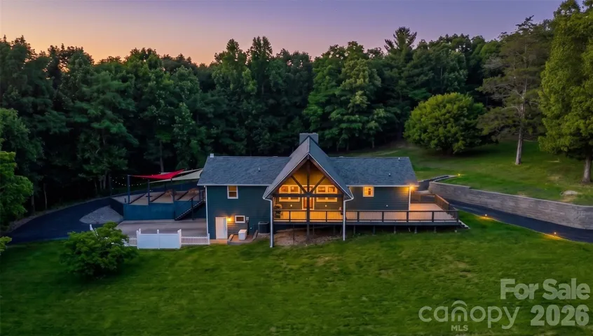 This twilight image showcases the primary residence, highlighting a beautifully crafted timber-framed outdoor area.