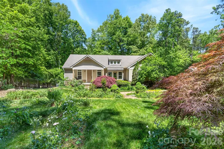 Front exterior of home overlooks a stunning fenced garden.