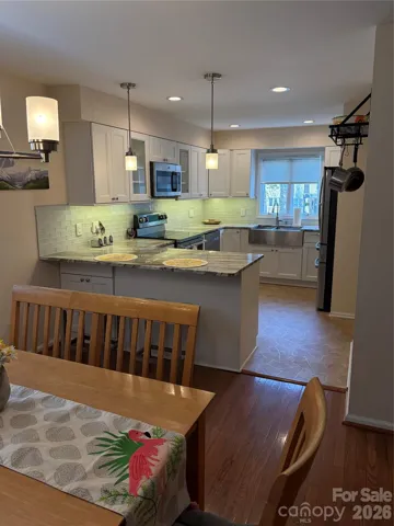 Light grey backsplash, granite countertops, recessed & under cab lgts