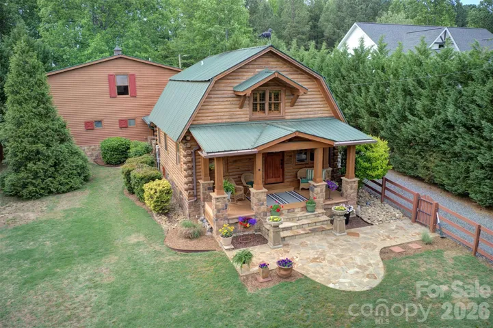 True log cabin with 3-car 2-story garage addition
