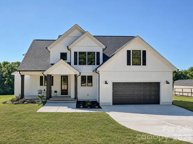 Stunning, new construction, custom built home with inviting front porch, manicured landscaping, and striking curb appeal set against a bright, open homesite. (Concept grass)