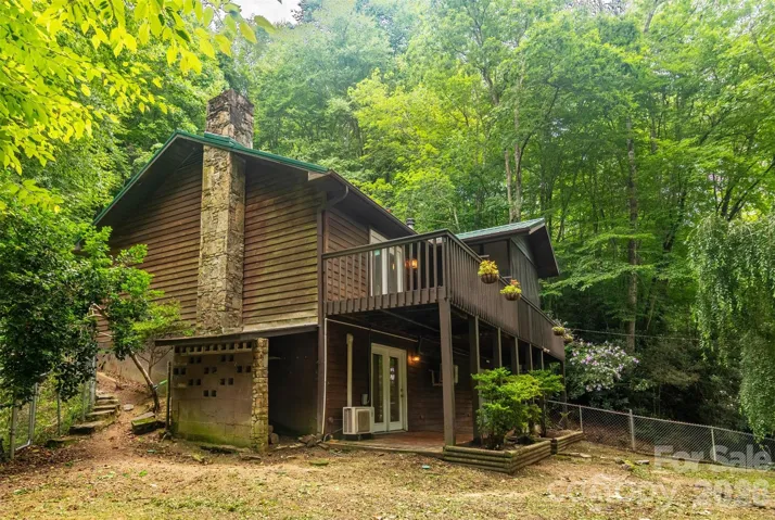 House and left side / front yard with the main level wooden deck and lower-level brick patio!