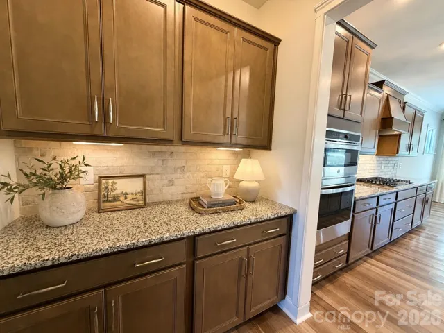 The gourmet kitchen flows seamlessly into a spacious, expertly designed butler’s pantry, featuring extensive cabinetry and generous counter space. This versatile area is perfect for hosting, whether utilized as a sophisticated buffet station, a dedicated coffee bar, or a fully stocked home spirits lounge. Ideally situated between the kitchen and the formal dining room, and positioned directly across from the large walk-in pantry, this space offers unparalleled convenience and storage. (Virtually staged)