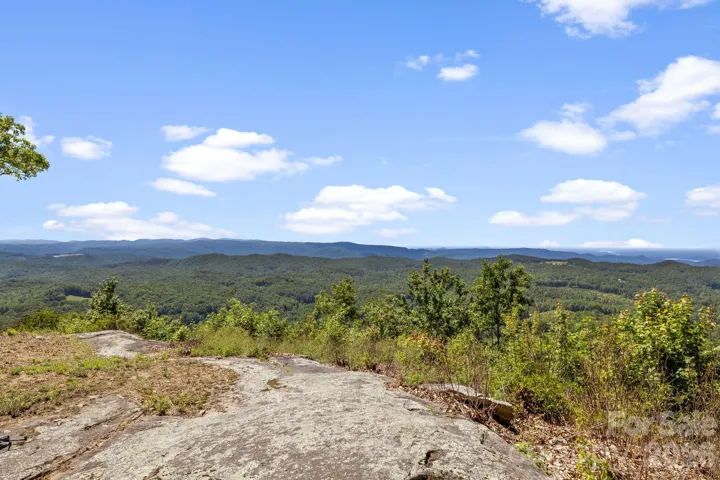 Expansive layered mountain views stretch across the horizon from this elevated vantage point, creating a stunning natural backdrop.