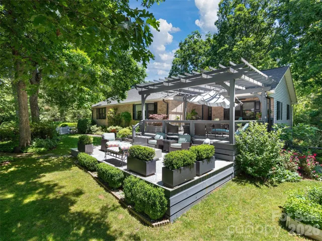 Expansive outdoor entertaining space featuring a custom designed pergola and  large open deck with firepit