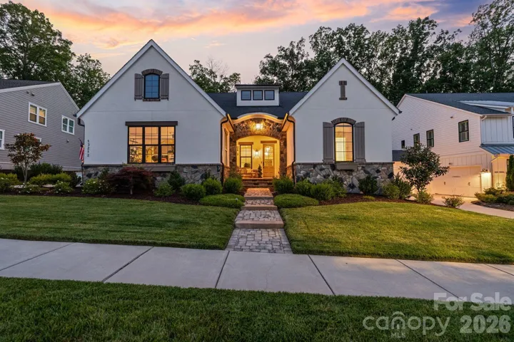 Beautifully illuminated at dusk, the home's striking architecture and inviting entry create an unforgettable first impression.