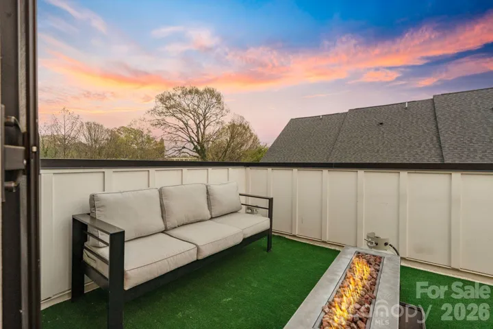 Private rooftop terrace with fire feature and Uptown skyline views