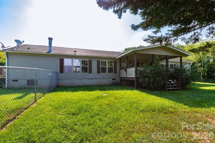 Back of the home featuring the covered porch, outdoor living space, and easy access to the backyard.