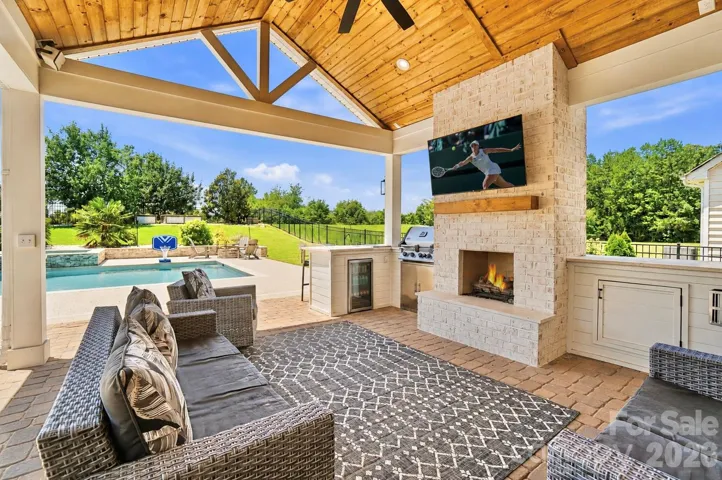 Resort Living at Home with Covered Porch - Featuring Brick Fireplace, Outdoor Kitchen, Vaulted Wood Ceilings overlooking the Luxury Pool and Beautiful Sunsets Daily