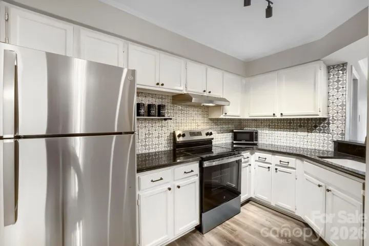 This refreshed kitchen shines with stainless steel appliances, sleek black hardware, and a stunning patterned tile backsplash. Crisp white cabinetry keeps the space feeling bright and move-in ready.