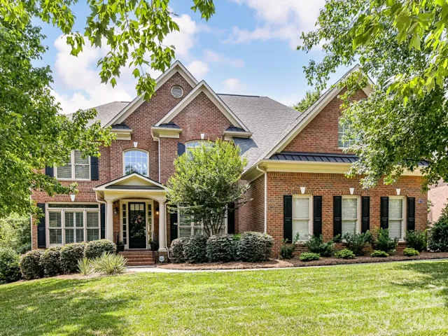 Stately full-brick exterior with timeless architectural details, manicured landscaping, and a welcoming covered front porch create exceptional curb appeal in this elegant residence.