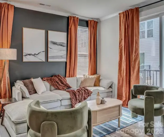 The inviting living room features abundant natural light, stylish modern finishes, and an open-concept design that flows seamlessly to the private balcony, creating the perfect space for relaxing or entertaining.