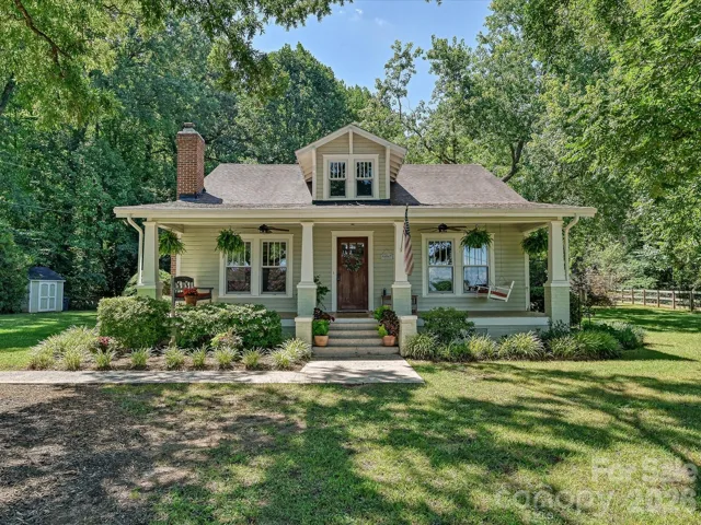 Classic Southern charm meets timeless curb appeal with a welcoming wraparound porch, mature shade trees, and a beautifully landscaped homesite.