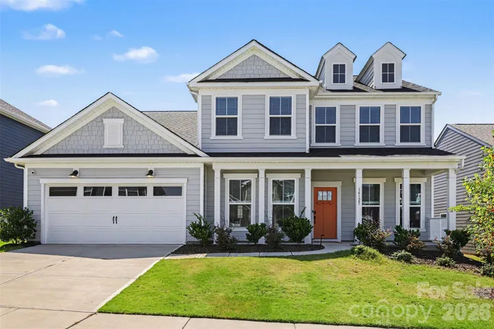 Front Exterior with Two Car Garage & Front Porch Sitting Area.