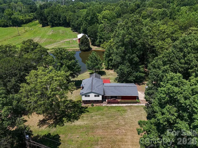 Aerial view 1 of main home with pond and horse barn in background