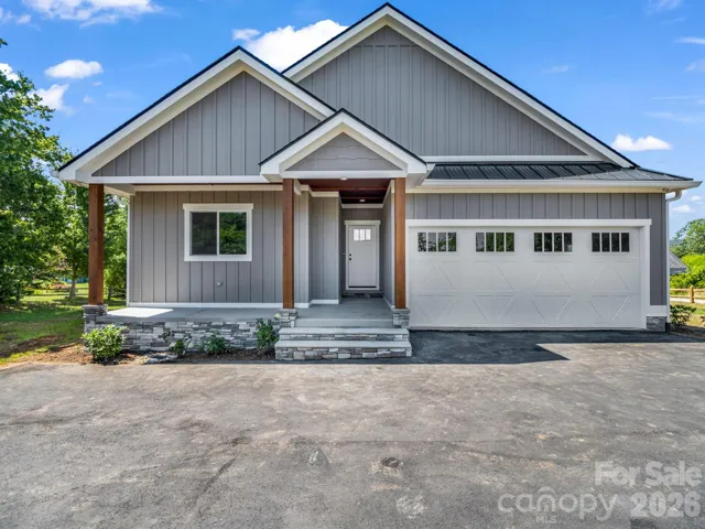 Front view of custom modern farmhouse, 2 car attached garage, covered front porch and hardyboard siding
