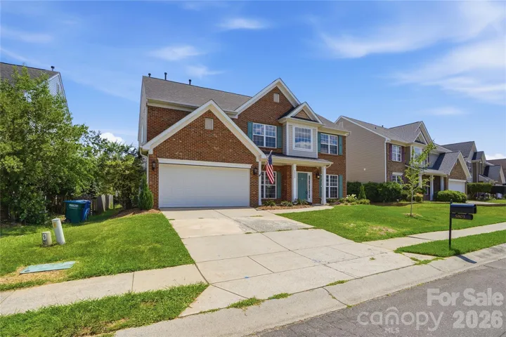 Brick-front two-story with refreshed landscaping and welcoming curb appeal