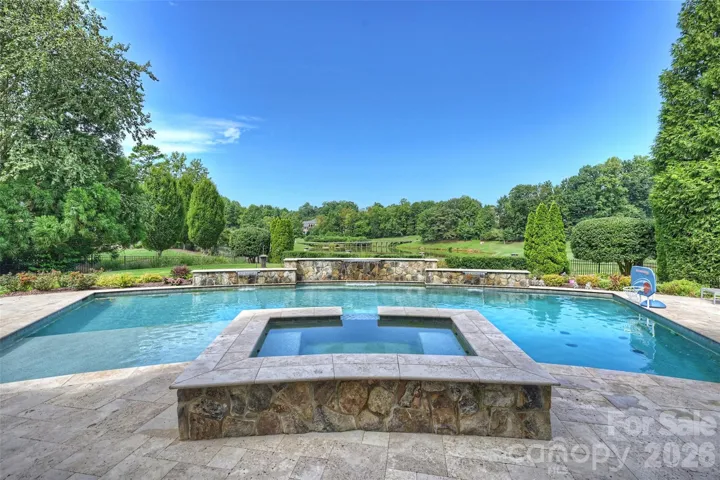 Ready for Summer! Gorgeous pool with sun shelf, hot tub and spill overs, overlooking the 13th hole/pond
