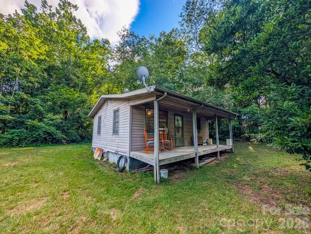 Front of property with covered front porch and crawl space access can be seen to left.