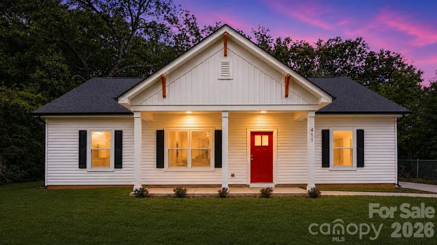 Digitally enhanced twilight exterior with a warm, welcoming arrival and charming curb appeal.