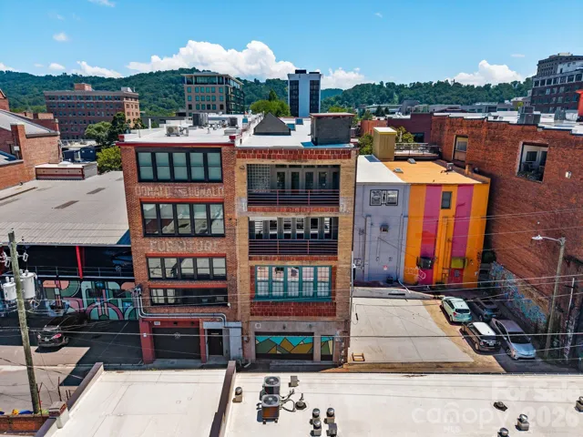 Rear aerial view of the building showcasing the distinctive architecture with Upper Covered Porch, Lower Covered Porch and Lower Level Garage Door.