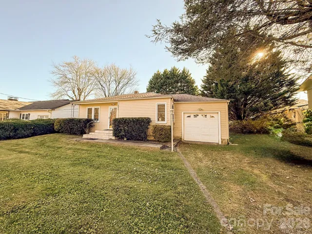 Front Exterior – Charming single-level cottage with an attached garage, level yard, and an unbeatable location just one block from downtown Brevard and beside the Brevard Bike Path.