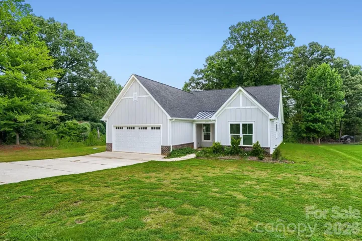 A picture-perfect front exterior with a peaked roofline and attached garage.