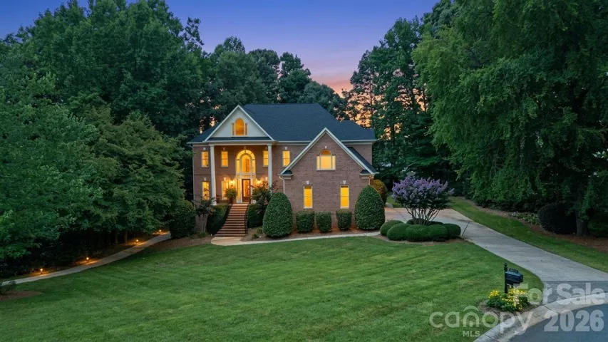 Virtual twilight exterior of 1009 Honors Court, Waxhaw NC, full-brick home on a 0.69-acre wooded cul-de-sac in Firethorne