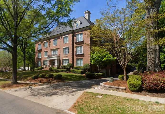 The welcoming approach to 974 Queens Road highlights the stately brick architecture, mature landscaping and tree-lined setting of this unique penthouse home.