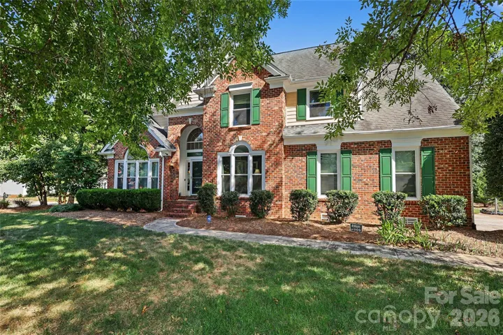 Mature landscaping surrounds this brick home