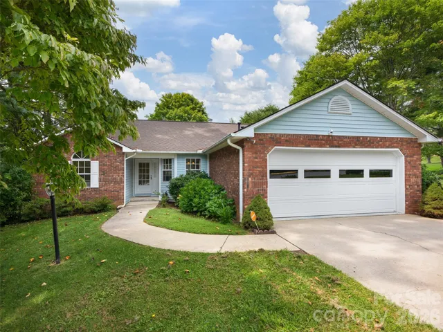 Welcome to 5 St Andrews Drive in Etowah, NC, a single-level 3-bedroom home with an attached two-car garage in the established Etowahs Reach community.