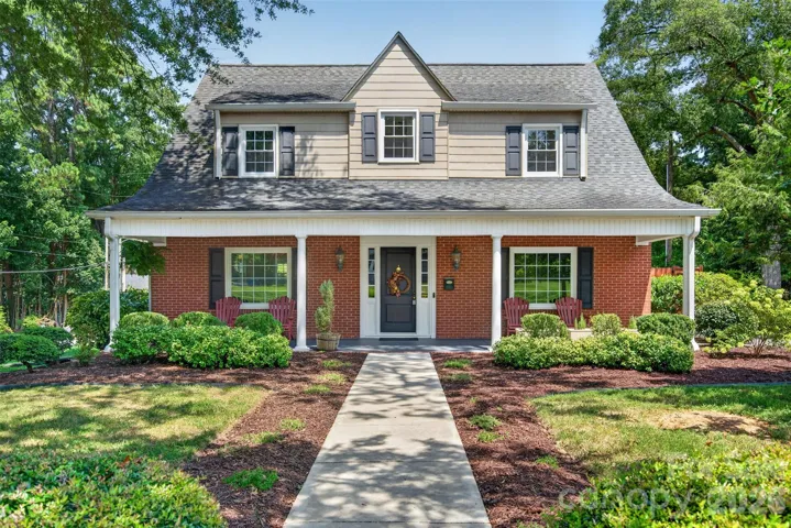 Charming Cape Cod style brick home with welcoming covered front porch, mature landscaping and classic architectural details.